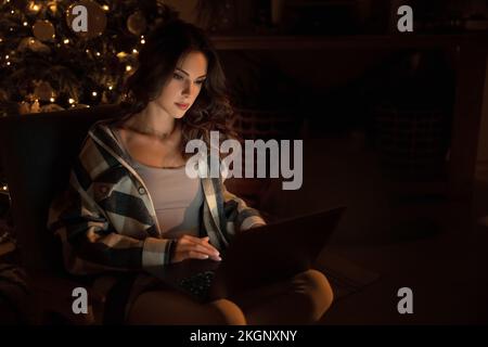 Schöne Frau, die sich zu Weihnachten auf dem Sofa entspannt Stockfoto