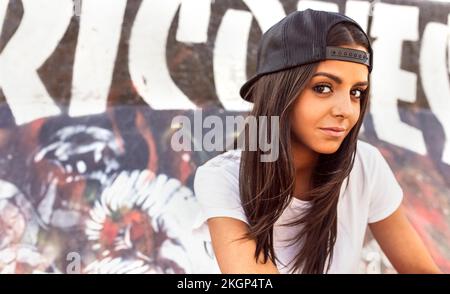 Porträt einer braunen jungen Frau mit Baseballmütze Stockfoto