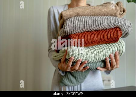 Frau mit mehrfarbigen Pullis zu Hause Stockfoto