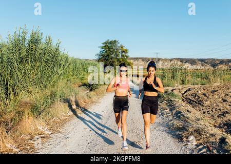 Frau mit Lehrerin, die auf dem Fußweg läuft Stockfoto