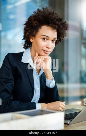 Geschäftsfrau mit der Hand am Kinn im Büro Stockfoto