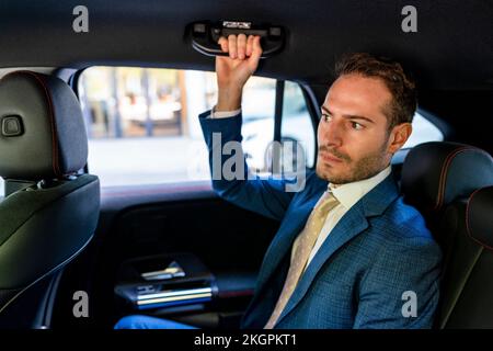 Ein Geschäftsmann mit Griff sitzt im Taxi Stockfoto