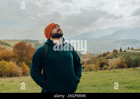 Lächelnder Mann mit Strickmütze, der mit geschlossenen Augen steht Stockfoto