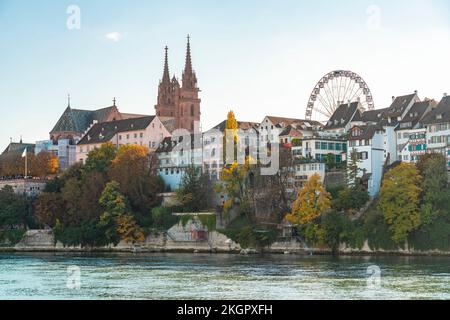 Schweiz, Basel-Stadt, Basel, Rhein mit verschiedenen Häusern, Basel Minster und Riesenrad im Hintergrund Stockfoto