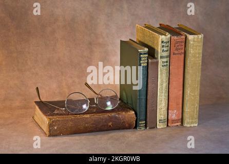 Ein Stapel klassischer Bücher, die darauf warten, gelesen zu werden, darunter Tarzan der Affen, die Virginian, Modern Detective Stories, Rogue River Feud, der Wind in the Stockfoto