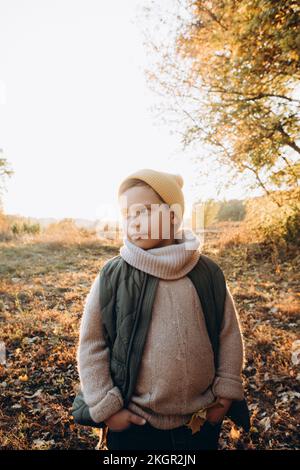 Rücksichtsvoller Junge mit Händen in Taschen, der auf dem Feld steht Stockfoto