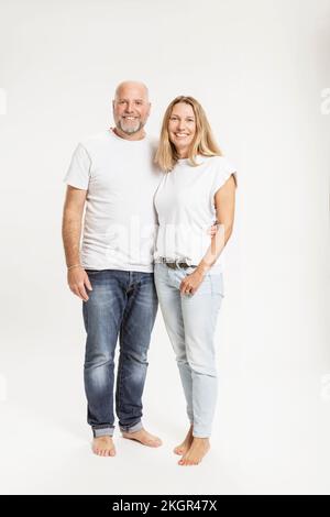 Ein lächelndes Paar, das vor weißem Hintergrund zusammensteht Stockfoto