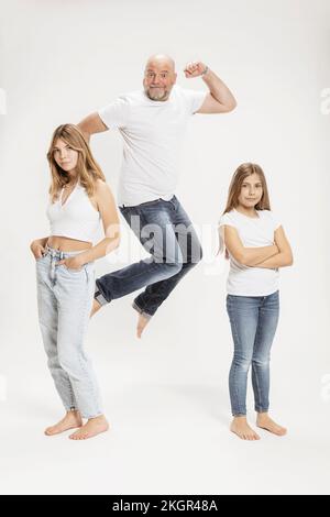 Ein fröhlicher Mann, der von Töchtern im Studio gesprungen ist Stockfoto