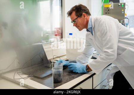 Wissenschaftler tragen Laborkittel am Laptop im Labor Stockfoto