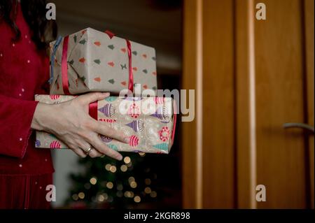 Frau mit Weihnachtsgeschenken zu Hause Stockfoto