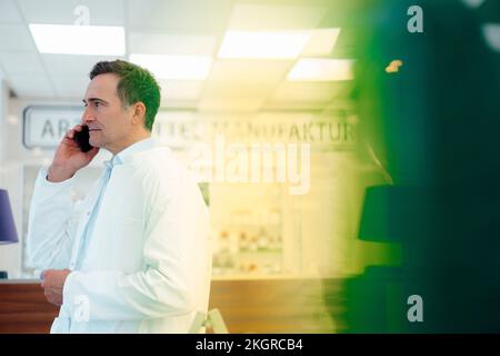 Apotheker telefoniert in der Apotheke Stockfoto