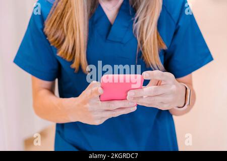 Krankenschwester mit Smartphone im Krankenhaus Stockfoto