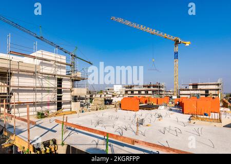 Deutschland, Baden-Wurttemberg, Weinstadt, Krane auf Baustelle im Vorort Stockfoto