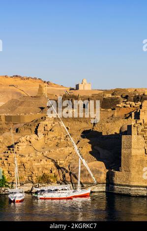 Ägypten, Assuan-Gouvernement, Assuan, Segelboote am Ufer des Nils mit Mausoleum von Aga Khan im Hintergrund Stockfoto