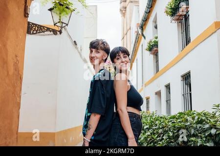 Ein lächelndes Paar, das in den Häusern hintereinander steht Stockfoto