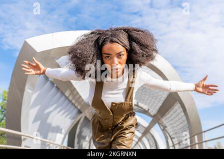 Eine ernste junge Frau mit ausgestreckten Armen Stockfoto