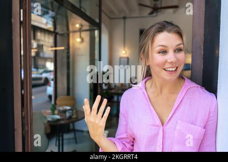 Eine glückliche Geschäftsfrau, die sich im Café vor der Tür unterhalten hat Stockfoto