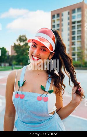 Lächelnde junge Frau mit Sonnenblende auf dem Sportplatz Stockfoto