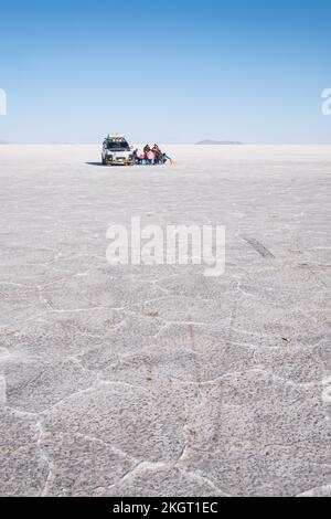 Geländewagen und Menschen, die den Tag auf dem Salar de Uyuni (Uyuni Salzplatte), Potosi Department, Bolivien genießen Stockfoto