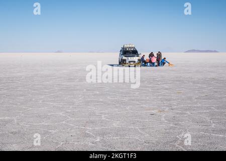 Geländewagen und Menschen, die den Tag auf dem Salar de Uyuni (Uyuni Salzplatte), Potosi Department, Bolivien genießen Stockfoto