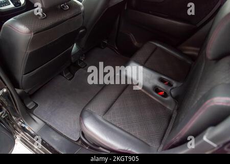 Reinigen Sie nach dem Waschen der Leder- und Stoffverkleidungen der Rücksitze im Innenraum eines Kei-Fahrzeugs, bereiten Sie sich vor dem Verkauf des Fahrzeugs vor. Stockfoto