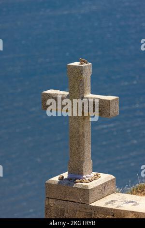 Einsames Steinkreuz in Cape Finisterre, Spanien, mit blauem Meereshintergrund Stockfoto