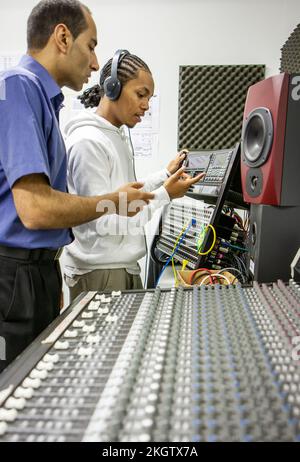 Musikstudenten: Studio Session. Ein aufstrebender Musikproduzent wird von seinem Lehrer in das Tonstudio eingeführt. Aus einer Reihe von zugehörigen Bildern. Stockfoto