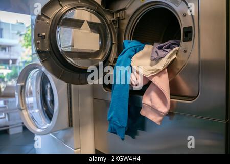 Frontlader-Waschmaschinen in einer öffentlichen Selbstbedienungs-Wäscherei Stockfoto