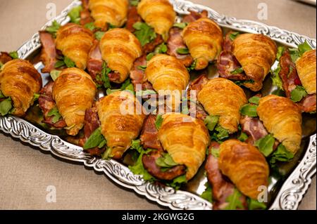 Tablett mit Vorspeisen Kuchen mit Salat und Fleisch auf dem Partytisch, Nahaufnahme Stockfoto