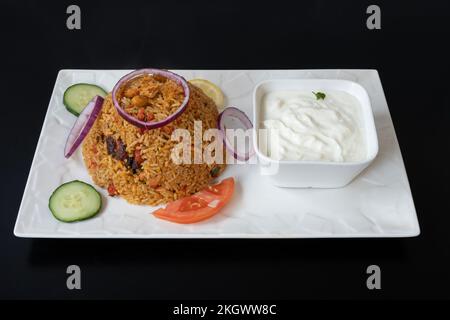 Indische Dishe kulinarisches Still Life. Hühnchen Biryani serviert mit Reis auf einem Teller Stockfoto