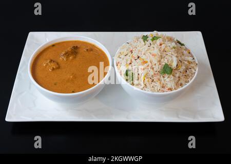 Indische Dishe kulinarisches Still Life. Lamm-Curry serviert mit Reis auf einem Glas Stockfoto
