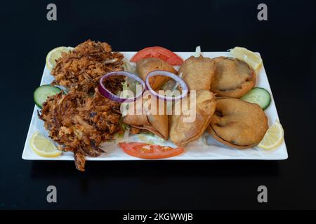 Indische Dishe kulinarisches Still Life. Auswahl an Donuts, serviert auf einem Teller Stockfoto