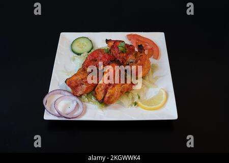 Indische Dishe kulinarisches Still Life. Hühnchen Tikka auf einer Platte serviert Stockfoto