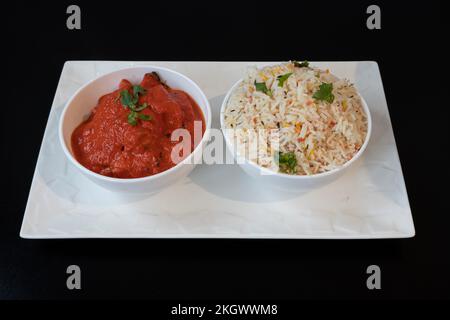 Indische Dishe kulinarisches Still Life. Hähnchen Tikka Massala serviert mit Reis auf einem Teller Stockfoto