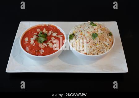 Indische Dishe kulinarisches Still Life. Butterhähnchen serviert mit Reis auf einem Teller Stockfoto