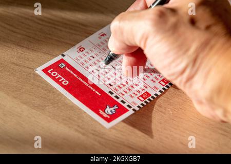 Nach London. GROSSBRITANNIEN - 11.20.2022. Eine Person, die die Spielnummer für einen Lotto-Gutschein auswählt. Stockfoto