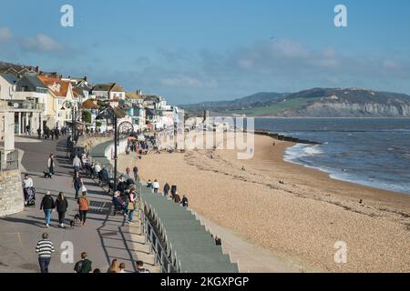 Leute spazieren entlang der Promenade am Meer in Lyme Regis, Dorset, England Stockfoto