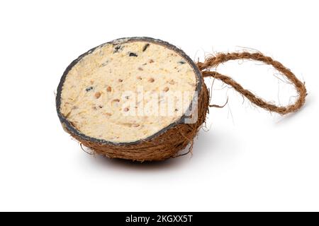 Halbierte Kokosnussschale gefüllt mit Kokosöl und Samen als Vogelfutter, isoliert auf weißem Hintergrund Stockfoto