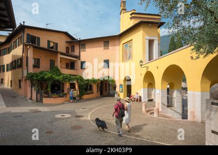 Gardone Gardasee, im Sommer sehen Sie ein erwachsenes Paar, das seinen Hund im malerischen Dorf Gardone Sopra über dem Gardasee in der Lombardei, Italien, spaziert Stockfoto