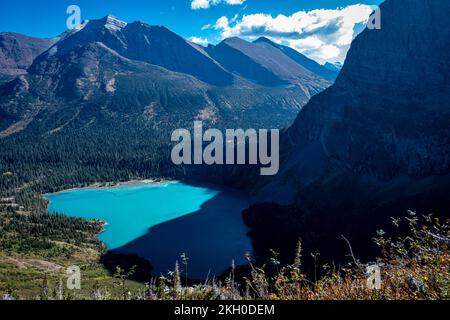 Blick auf den eisigen türkisfarbenen Grinnell Lake im Schatten des Angel Wing im Glacier-Nationalpark Stockfoto