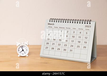 Kalender vom März 2023 und eine kleine Oldtimer auf dem Schreibtisch Stockfoto