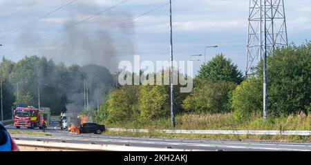 Feuerwehr löschte einen Autobrand nach einem Vorfall auf der Autobahn, Großbritannien. Stockfoto