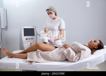 Die Frau wird im Schönheitssalon mit Laser-Cellulite entfernt Stockfoto
