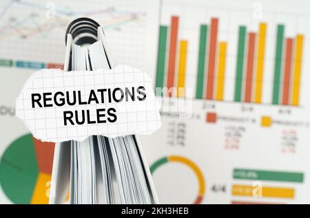 Geschäftskonzept. In den Geschäftsdiagrammen befindet sich ein Notizbuch, auf dem sich eine Papierplatte mit der Aufschrift „Vorschriften“ befindet Stockfoto