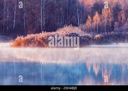 Nebel über der Seenoberfläche am Herbstmorgen. Stockfoto