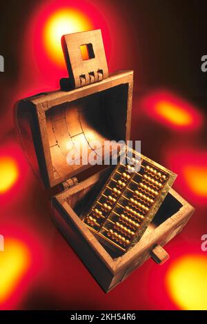 Hölzerne Truhe mit Abacus auf warmem Hintergrund Stockfoto