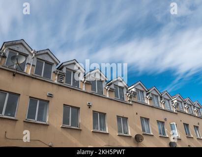 Eine Reihe kleiner Apartments mit blauem Himmel in Irland, Foto im Freien Stockfoto