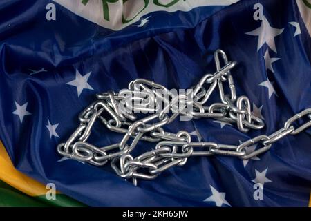 Kette und brasilianische Flagge symbolisieren Sklaverei im Land, obere Ansicht Stockfoto