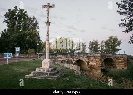 Steinernen Wegkreuzung entlang des Camino de Santiago in Sahagún an der historischen Puente Canto Brücke über den Fluss Cea. Stockfoto