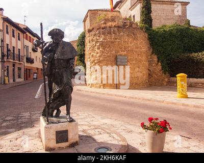 Lebendige Statue eines Pilgers und Überreste der mittelalterlichen Stadtmauer am Eingang zum historischen Zentrum von Carrión de los Condes ein wichtiger Halt auf dem Weg nach St. James von der französischen Grenze nach Santiago de Compostela. Stockfoto